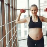 woman in black sports bra and black shorts holding red kettle bell