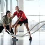 a woman holding ropes beside a trainer