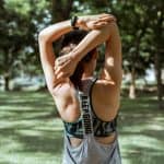 unrecognizable female athlete stretching muscles of arms and back