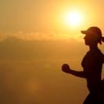 woman with white sunvisor running