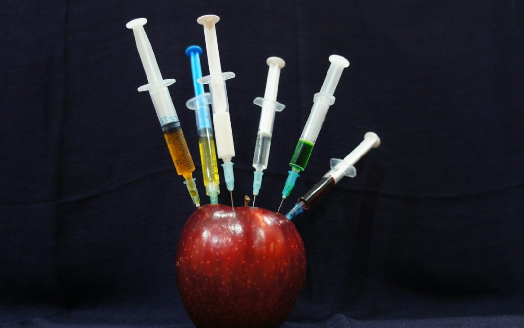 apple fruit with plastic syringes